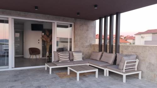 扎达尔Villa Queen的阳台的天井配有沙发和桌子