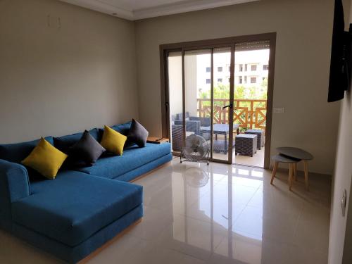 萨伊迪耶Appartement avec piscine à saidia Climatisation et Wifi的客厅配有蓝色的沙发和黄色的枕头。