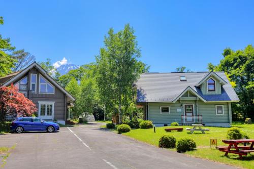 山中湖村First Villa的车道上停放一辆蓝色汽车的房子