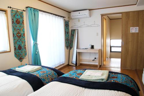 东京HAMA HILLS Shinjuku的一间卧室设有两张床和窗户。