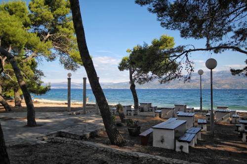 苏佩塔尔Apartments by the sea Supetar, Brac - 4274的一个带野餐桌和海滩的公园