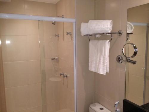 新伊瓜苏梦布隆钻石公寓式酒店的带淋浴、卫生间和毛巾的浴室