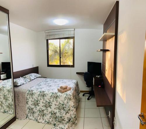 巴西利亚Life Resort - 2 quartos, 2 banheiros的一间卧室配有一张床、一张书桌和一个窗户。