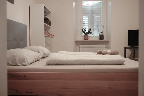 卡尔达罗Chalet 1897的一张配有白色床单和枕头的大床