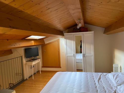 西尼加利亚TRA IL CENTRO E IL MARE的一间带木制天花板、一张床和电视的卧室