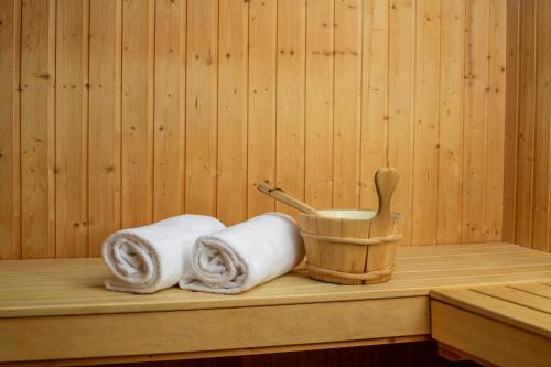 克莱恩 蒙塔纳Hotel-Restaurant Le Mont Paisible, Crans-Montana的一间桑拿浴室,配有两条毛巾和木桶