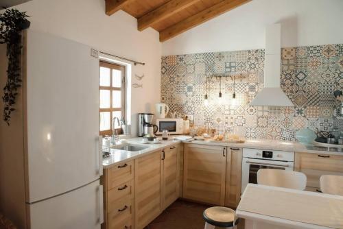 楼尔Cosy Farmhouse Quinta da Eira 140 years old的厨房配有木制橱柜和白色冰箱。