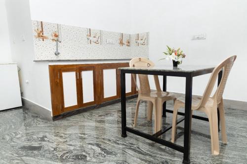 蓬蒂切里BrightMoon_Homestay的厨房配有黑色的桌子和两把椅子