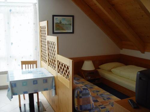 斯图加特祖尔所奈旅馆的一间卧室配有一张床、一张桌子和一台电视。