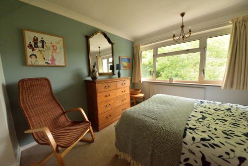 新奥尔斯福德Cosy house, a train spotter's delight!的一间卧室配有一张床、一把椅子和镜子