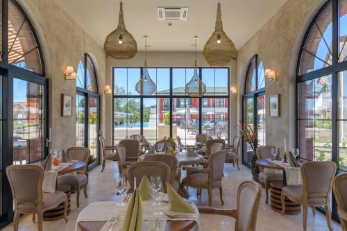克兰内沃Luxury Villas in Therma Village - Mineral Pool & SPA的餐厅设有桌椅和大窗户。