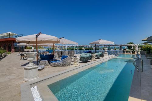 克兰内沃Luxury Villas in Therma Village - Mineral Pool & SPA的一个带桌椅和遮阳伞的游泳池