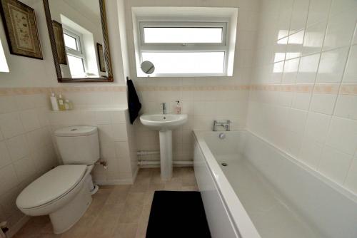 新奥尔斯福德Cosy house, a train spotter's delight!的浴室配有卫生间、盥洗盆和浴缸。