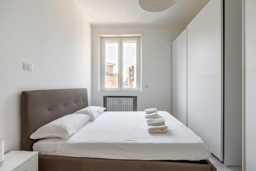 米兰Garibaldi & Gae Aulenti Modern Apt with Private Parking!的一间卧室配有一张带白色床单的床和一扇窗户。