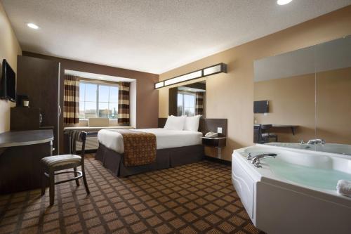 锡达拉皮兹Sleep Inn的酒店客房配有一张床和浴缸。