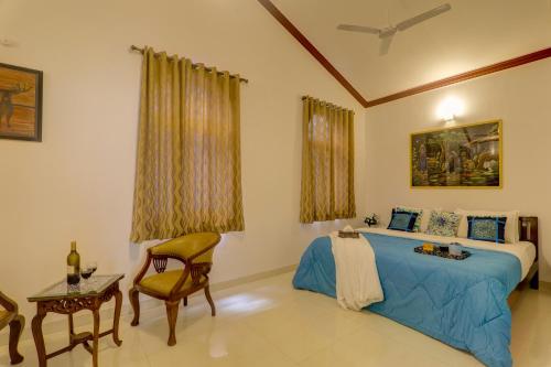巴加Ludo Private Pool Villa, WiFi-Caretaker-Parking, North Goa的卧室配有1张床、1张桌子和1把椅子