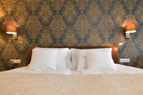 罗加斯卡斯拉提纳TI Hotel的卧室配有带白色枕头和壁纸的床