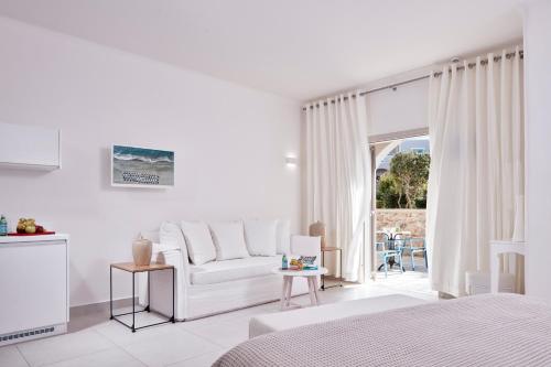 佩里沃罗圣米拉马雷海滩度假村的白色的客房设有白色的沙发和窗户。