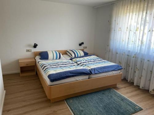 格恩斯巴赫Gästehaus Murgtalblick的一间卧室配有蓝色和白色床单