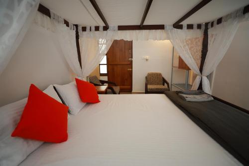 马迪凯里Ayla Homes的卧室配有带红色枕头的大型白色床