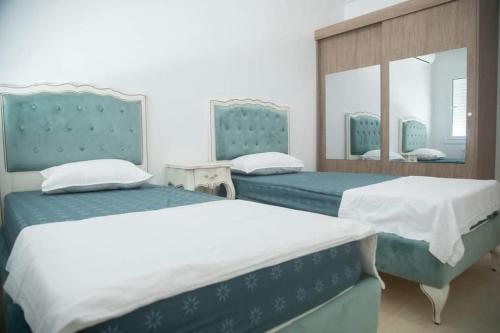 莫纳斯提尔Splendide appartement au PALM LAKE RESORT的一间卧室配有两张床和镜子