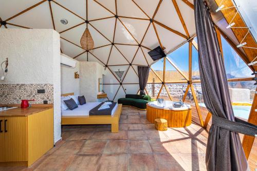 卡斯Kalkan Dome Suites & Deluxe-Glamping Holiday in Kalkan的帐篷内带一张床和一张桌子的房间