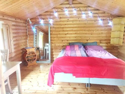 KarkkilaStable Cottage的木制客房内的一间卧室,配有一张床