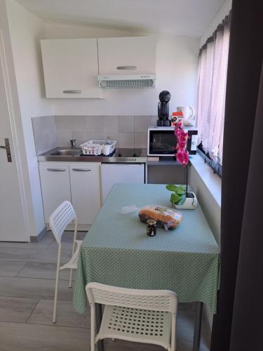 沙特拉永普拉日Appartement Aix (1 à 2 personnes)的厨房配有桌子和桌椅