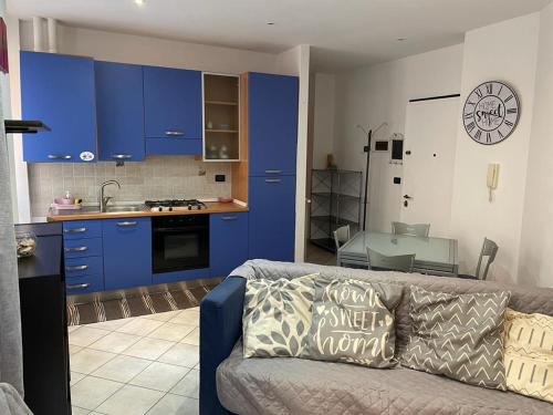 阿拉西奥Casa Celeste, bilocale nel pieno centro di Alassio的带沙发的客厅和带蓝色橱柜的厨房。