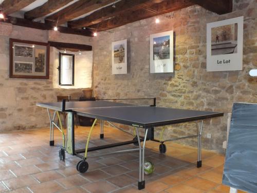 罗卡马杜尔Gîte Rocamadour L'Oustal de Beline free wifi的砖墙房里的乒乓球桌