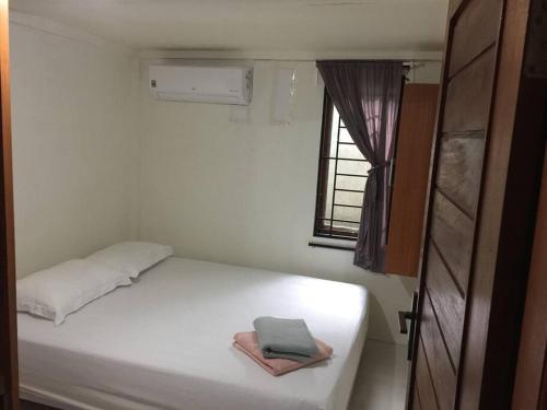 班达亚齐Banda Aceh Batoh Homestay - private - fits up to 10 persons的窗户客房内的一张白色床