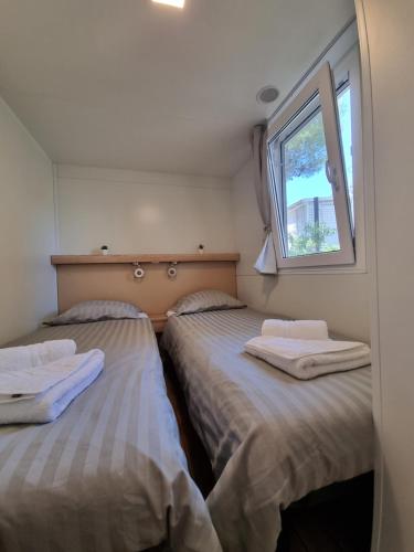 耶泽拉Premium Mobile Home ZEN SPOT 277的小型客房 - 带2张床和窗户