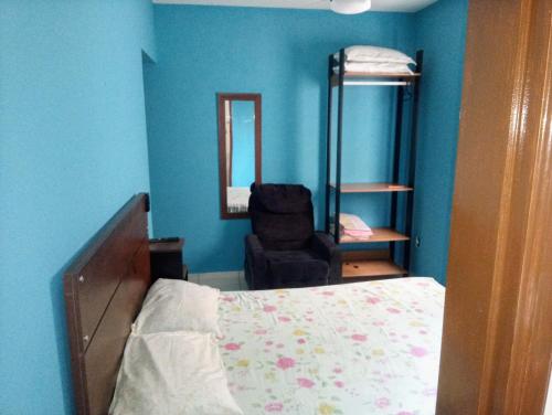 大普拉亚Apartamento Vidal con Wi-Fi Praia Grande Avi的一间卧室配有一张床、一把椅子和镜子