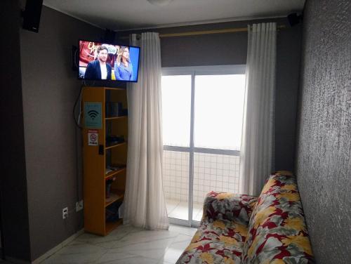 大普拉亚Apartamento Vidal con Wi-Fi Praia Grande Avi的客厅配有电视、沙发和窗户。