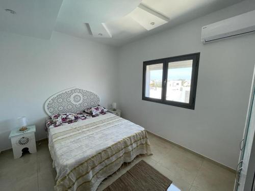乌姆苏克La casa blanca的白色的卧室设有床和窗户