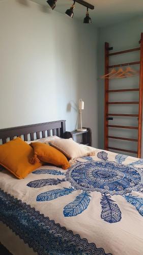 利耶帕亚Mareena_apartments的一张带蓝色和白色毯子以及橙色枕头的床