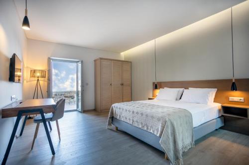阿里奥波利斯Armantanis Luxury Suites的一间卧室配有一张床、一张桌子和一张书桌