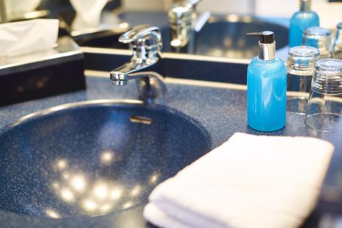 康斯坦茨酷一酒店的浴室水槽和蓝色肥皂瓶