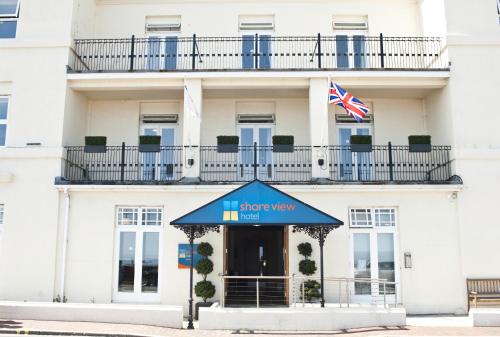 伊斯特布恩岸景酒店的一座有蓝色遮阳篷和美洲国旗的建筑