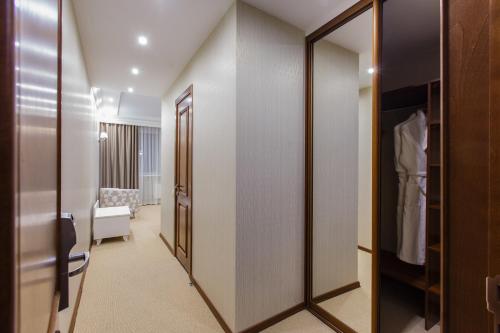 托木斯克典雅酒店的带步入式衣柜和镜子的房间