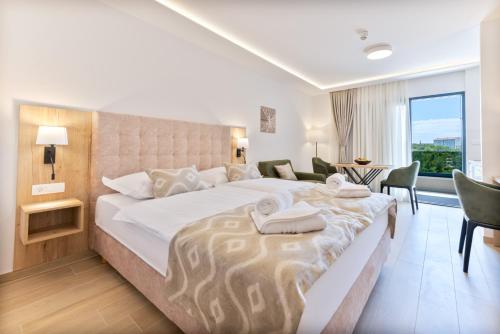普罗马尼亚Aparthotel Remaneo的一间带大床的卧室和一间客厅