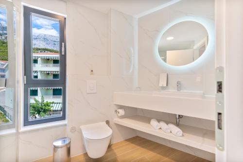 普罗马尼亚Aparthotel Remaneo的白色的浴室设有水槽和镜子