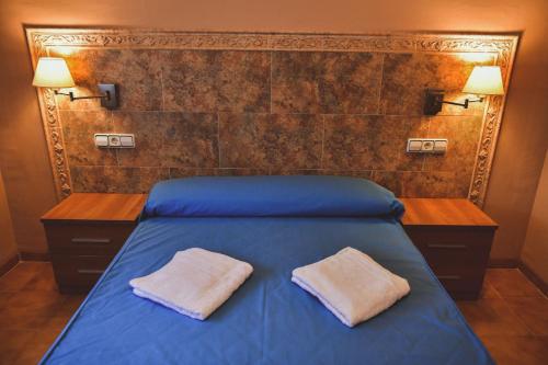 托雷夫兰卡TEPINSA · Alquiler de Apartamentos的一间卧室配有蓝色的床和两个枕头