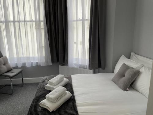 伦敦拉夫纳格拉酒店的一间卧室配有一张床,上面有两条毛巾