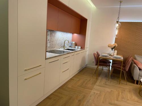 威利兹卡CRYSTAL CAVE Apartment的厨房配有白色橱柜和小桌子