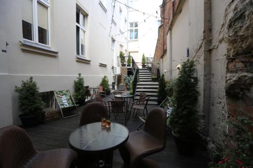 华沙Deja Vu Hostel的室外庭院设有桌椅和楼梯。