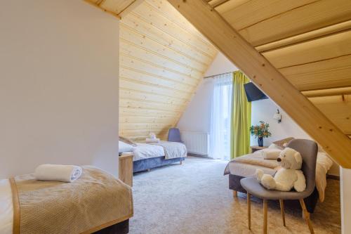Białka TatrzanskaSuchowianka Ski&Relax的一间卧室设有两张床,椅子上配有泰迪熊