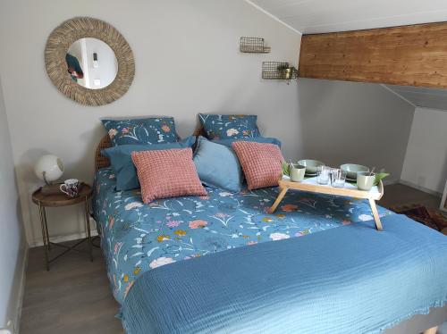 PanossasCampagne et Jacuzzi ... c'est cosy le Bumble Bee !的一张带蓝色棉被的床和一张桌子