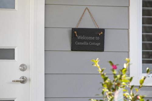 贝里马Camellia Cottage的带有可读到颅骨癌的标志的门