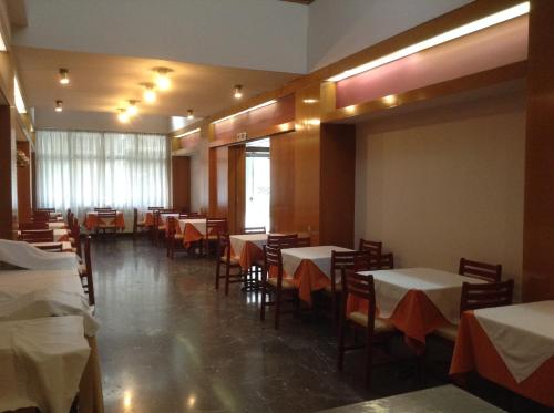 沃洛斯伊莱克特拉酒店的用餐室配有桌椅和白色的桌布